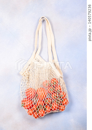 Reusable net bag full of fresh cherry tomatoes Reusable net bag full of fresh cherry tomatoes 140579236