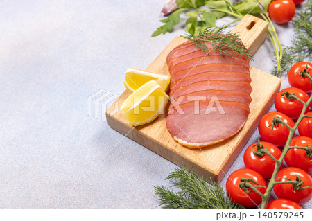 Sliced smoked pork loin with fresh tomatoes and lemon 140579245