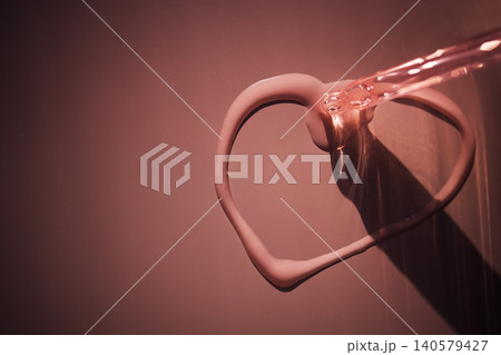 Liquid pink substance forming a heart shape on a smooth surface, with soft lighting creating shadows and highlights, emphasizing the texture and color of the material Liquid pink substance forming a heart shape on a smooth surface, with soft lighting creating shadows and highlights, emphasizing the texture and color of the material 140579427
