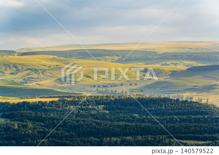 Layers of green mountains and hills in the haze during sunset. Panoramic View of Green hills and Meadow. 140579522