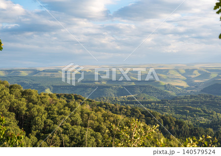 Layers of green mountains and hills in the haze during sunset. Panoramic View of Green hills and Meadow. Layers of green mountains and hills in the haze during sunset. Panoramic View of Green hills and Meadow. 140579524