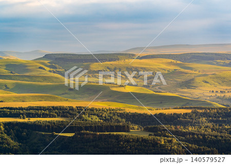 Layers of green mountains and hills in the haze during sunset. Panoramic View of Green hills and Meadow. Layers of green mountains and hills in the haze during sunset. Panoramic View of Green hills and Meadow. 140579527