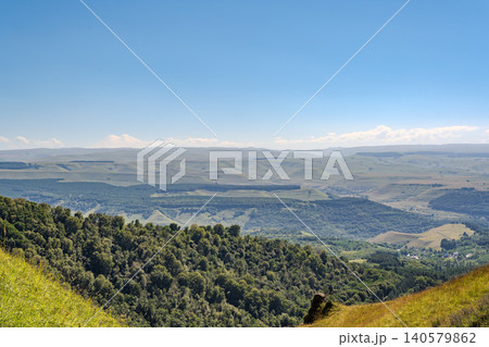 Panoramic view of the green valley and the snowy peak of Mount Elbrus on the horizon against the blue sky on a sunny clear morning in Kislovodsk Stavropol territory, Russia Panoramic view of the green valley and the snowy peak of Mount Elbrus on the horizon against the blue sky on a sunny clear morning in Kislovodsk Stavropol territory, Russia 140579862