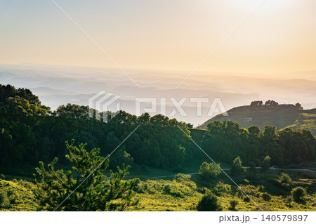 Layers of green mountains and hills in the haze during sunset. Panoramic View of Green hills and Meadow. Layers of green mountains and hills in the haze during sunset. Panoramic View of Green hills and Meadow. 140579897