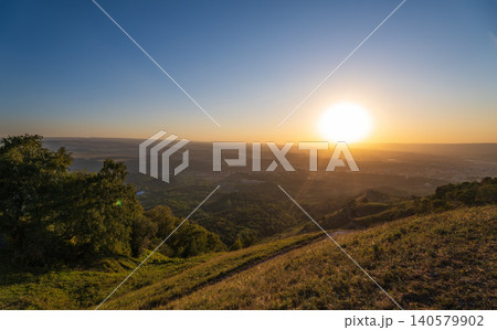 View of the mountains and Kislovodsk from the observation decks of the Kislovodsk Park. Evening sunset over the mountains of Kislovodsk. View of the mountains and Kislovodsk from the observation decks of the Kislovodsk Park. Evening sunset over the mountains of Kislovodsk. 140579902