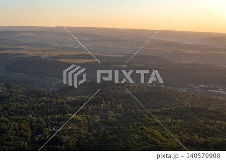 Layers of green mountains and hills in the haze during sunset. Panoramic View of Green hills and Meadow. 140579908