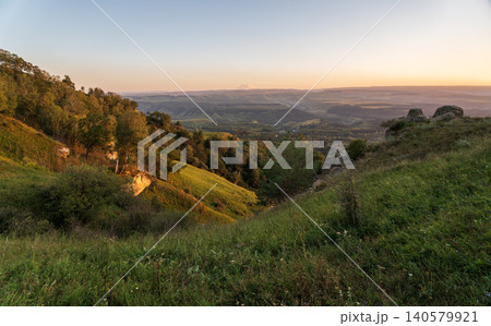 View of the mountains and Kislovodsk from the observation decks of the Kislovodsk Park. Evening sunset over the mountains of Kislovodsk. View of the mountains and Kislovodsk from the observation decks of the Kislovodsk Park. Evening sunset over the mountains of Kislovodsk. 140579921