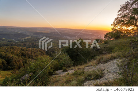 View of the mountains and Kislovodsk from the observation decks of the Kislovodsk Park. Evening sunset over the mountains of Kislovodsk. View of the mountains and Kislovodsk from the observation decks of the Kislovodsk Park. Evening sunset over the mountains of Kislovodsk. 140579922