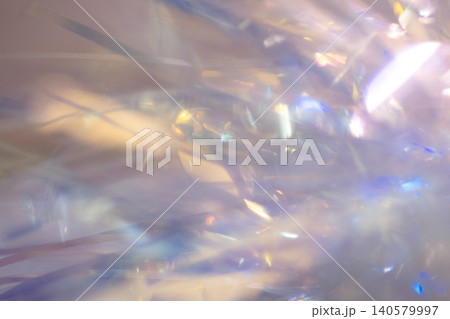 Abstract close-up of colorful shiny tinsel strands reflecting light, creating a vibrant and festive background suitable for holiday decorations and celebrations Abstract close-up of colorful shiny tinsel strands reflecting light, creating a vibrant and festive background suitable for holiday decorations and celebrations 140579997