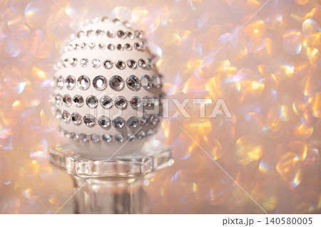 Decorative egg adorned with rhinestones displayed on a glass pedestal against a shimmering pastel background, ideal for Easter or festive celebrations Decorative egg adorned with rhinestones displayed on a glass pedestal against a shimmering pastel background, ideal for Easter or festive celebrations 140580005