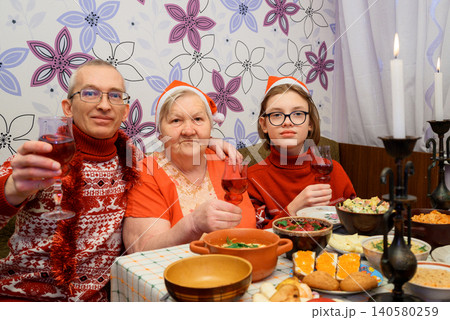 family celebrates new year and christmas at a festive table with wine glasses 140580259