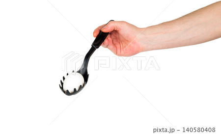 chicken egg in a black pasta spoon on a white background 140580408