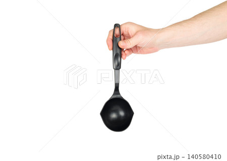 black plastic kitchen ladle in a hand on a white background black plastic kitchen ladle in a hand on a white background 140580410