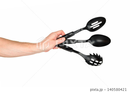 kitchen spoons in a man's hand on a white background kitchen spoons in a man's hand on a white background 140580421