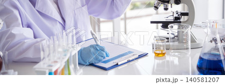 Banner Asian woman scientist hand write note research in medical lab look at science microscope. Panorama biology chemistry lab. Asian Female technician laboratory using microscope with copy space 140581207