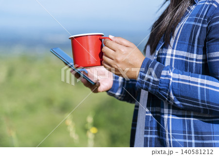 Close up Woman hand holding black coffee cup in green garden cafe. Hands of businesswoman love drinking hot coffee. business women with black coffee or hot chocolate in coffee shop. Caffeine drinking Close up Woman hand holding black coffee cup in green garden cafe. Hands of businesswoman love drinking hot coffee. business women with black coffee or hot chocolate in coffee shop. Caffeine drinking 140581212