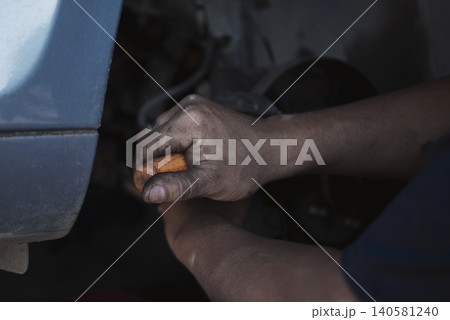 Close up Mechanic man hands repairing car auto repair shop uses jack change tyre. Man hands fixing Shock absorber machinery vehicle mechanical service. Vehicle Car overhaul maintenance engineer Close up Mechanic man hands repairing car auto repair shop uses jack change tyre. Man hands fixing Shock absorber machinery vehicle mechanical service. Vehicle Car overhaul maintenance engineer 140581240