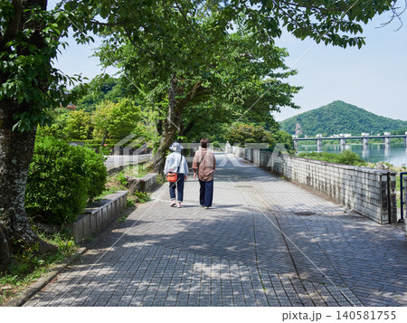 初夏の朝の犬山市の木曽川遊歩道で歩くシニア女性たちの姿 140581755