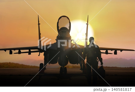 Jet fighter pilot walking during sunset on air force base airfield Jet fighter pilot walking during sunset on air force base airfield 140581817
