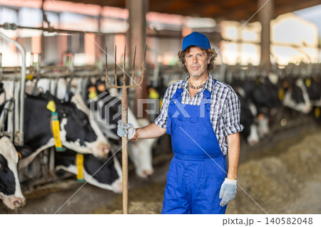 Portrait of male farm employee in blue jumpsuit 140582048