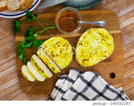 Cumin cheese with cut out segment on wooden board with sprig of rosemary and cumin 140582267