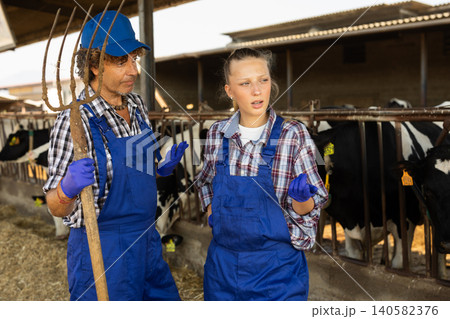 Young female and male farmers discussing something Young female and male farmers discussing something 140582376