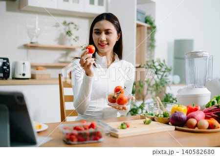 Healthy woman preparing fresh vegetables at home kitchen. Clean eating, nutrition, cooking, wellness lifestyle, vegetarian food, diet concept and healthy living inspiration. 140582680