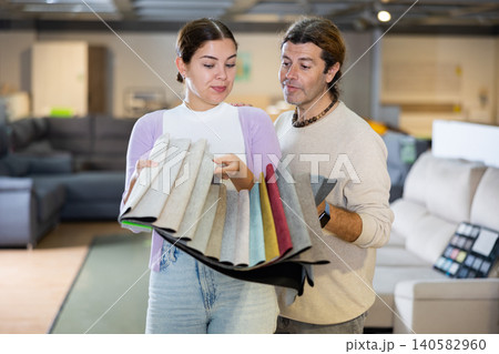 Man and woman picking upholstery materials in furniture store Man and woman picking upholstery materials in furniture store 140582960
