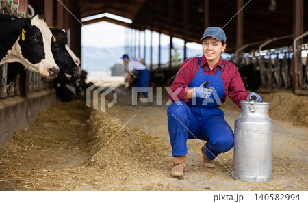 Farmer woman is holding can at cow farm Farmer woman is holding can at cow farm 140582994