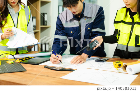 Creative architect projecting on the big drawings with architectural project at construction site at desk Creative architect projecting on the big drawings with architectural project at construction site at desk 140583013