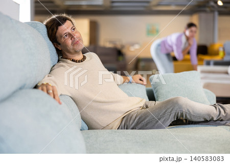 Man looking for sofa in furniture showroom 140583083