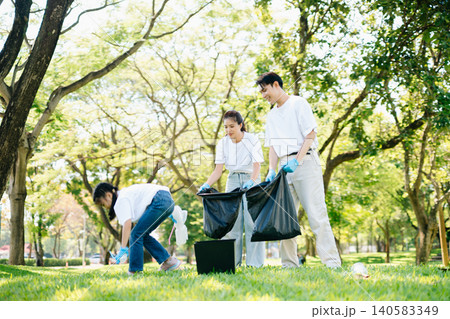 Joyful family volunteering to clean up a green park together. A positive lifestyle scene promoting eco-awareness, teamwork, and love for nature. Joyful family volunteering to clean up a green park together. A positive lifestyle scene promoting eco-awareness, teamwork, and love for nature. 140583349