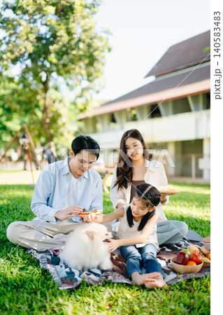 Loving family picnic in a sunny green park with their fluffy dog. A joyful outdoor lifestyle moment full of warmth, nature, and togetherness. Loving family picnic in a sunny green park with their fluffy dog. A joyful outdoor lifestyle moment full of warmth, nature, and togetherness. 140583483