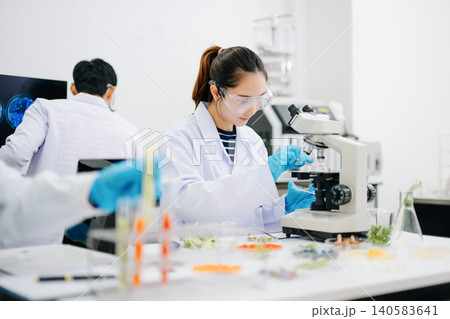 Professional scientists performing laboratory research with microscopes, biotechnology testing, medical innovation and healthcare science in a modern lab. 140583641