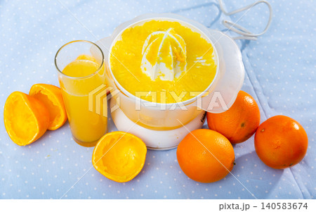 Electric orange juicer white on wooden table Electric orange juicer white on wooden table 140583674