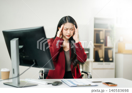 Asian business woman is stressed, bored, and overthinking from working on a tablet at the modern office. 140583698