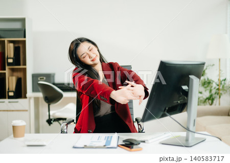 Overworked young Asian businesswoman office worker suffering from neck pain after had a long day at her office desk. office syndrome concept Overworked young Asian businesswoman office worker suffering from neck pain after had a long day at her office desk. office syndrome concept 140583717