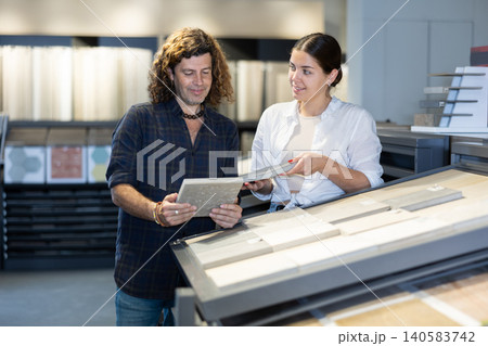 Husband and wife shopping for bathroom tiles together in hardware store 140583742