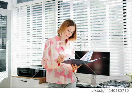 Business woman reviewing documents in a bright modern office. planning, and professional workplace concepts. Business woman reviewing documents in a bright modern office. planning, and professional workplace concepts. 140583750