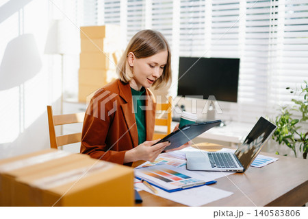 Female designer choosing a color palette while working on a creative project in a bright modern workspace. Female designer choosing a color palette while working on a creative project in a bright modern workspace. 140583806