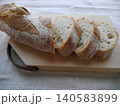 スペルト小麦フランスパンのスライスと木製カッティングボード 140583899