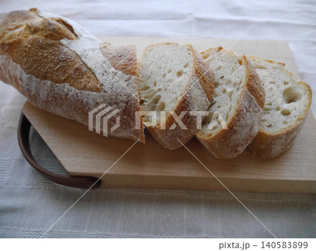 スペルト小麦フランスパンのスライスと木製カッティングボード 140583899