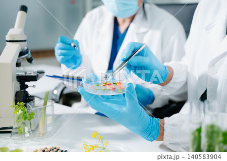 Scientists performing food testing in laboratory. Biotechnology research, GMO analysis, healthcare innovation, nutrition safety and pharmaceutical development. Scientists performing food testing in laboratory. Biotechnology research, GMO analysis, healthcare innovation, nutrition safety and pharmaceutical development. 140583904