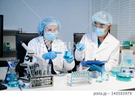 Scientists working together in laboratory analyzing samples and data on digital screen, representing medical research, biotechnology innovation Scientists working together in laboratory analyzing samples and data on digital screen, representing medical research, biotechnology innovation 140583979