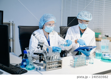 Scientists working together in laboratory analyzing samples and data on digital screen, representing medical research, biotechnology innovation Scientists working together in laboratory analyzing samples and data on digital screen, representing medical research, biotechnology innovation 140583982
