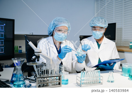 Scientists working together in laboratory analyzing samples and data on digital screen, representing medical research, biotechnology innovation Scientists working together in laboratory analyzing samples and data on digital screen, representing medical research, biotechnology innovation 140583984
