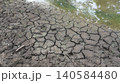 Cracked Dry Soil Beside Water During Drought 140584480