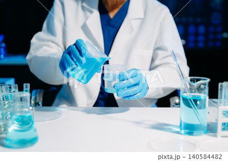 Scientist mixing chemical solutions in a modern laboratory, showcasing biotech innovation, chemistry research, diagnostics, and scientific development. Scientist mixing chemical solutions in a modern laboratory, showcasing biotech innovation, chemistry research, diagnostics, and scientific development. 140584482