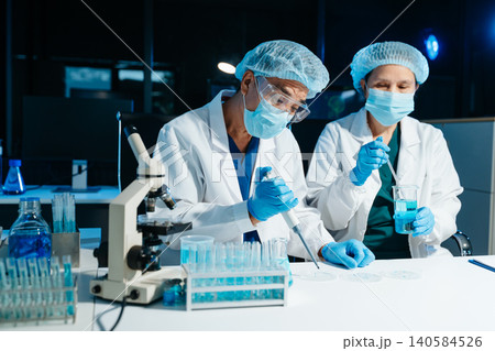 Senior medical scientists working in laboratory, reviewing research data and experiment results, reflecting healthcare, science, teamwork Senior medical scientists working in laboratory, reviewing research data and experiment results, reflecting healthcare, science, teamwork 140584526
