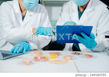Scientists developing lab grown meat in food science laboratory. Biotechnology research on sustainable protein, alternative agriculture and future food Scientists developing lab grown meat in food science laboratory. Biotechnology research on sustainable protein, alternative agriculture and future food 140584705